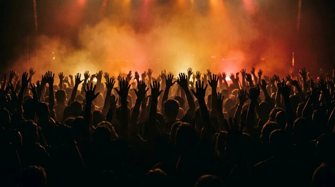Silhouetted raised hands in a backlit hall